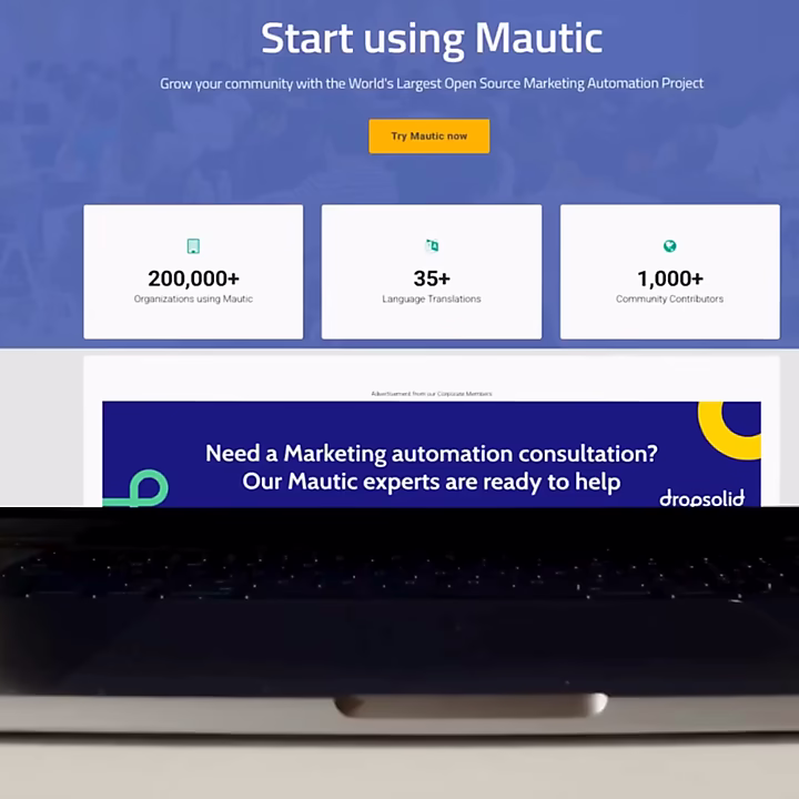 Ein Laptop zeigt die Mautic-Website mit der Überschrift 'Start using Mautic'. Wichtige Zahlen wie '200,000+ Organizations using Mautic' und '1,000+ Community Contributors' werden animiert dargestellt, während die Plattform vorgestellt wird.